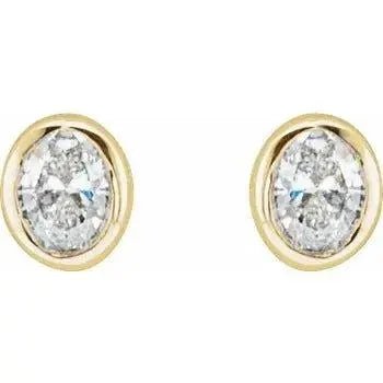 Close-up of gold earrings featuring bezel-set oval diamonds