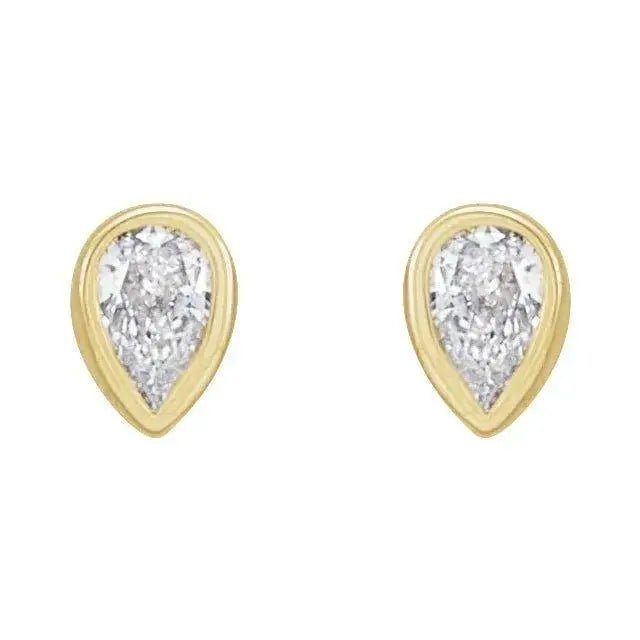 Close-up of gold earrings featuring bezel-set pear diamonds