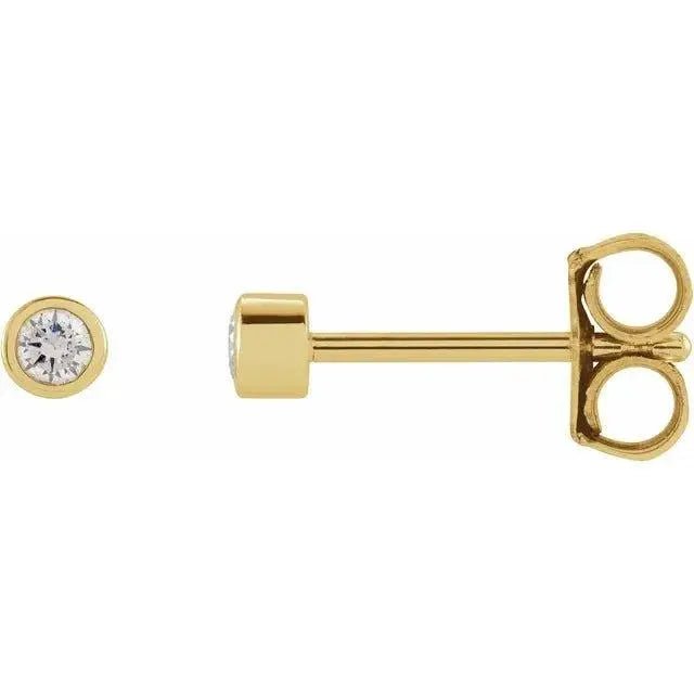 Close-up photo of 14K gold round diamond bezel stud earrings, handcrafted in NYC.