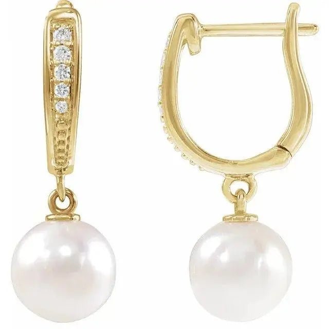 Close-up photo of 14K gold white pearl and diamond dangle earrings, handcrafted in NYC.