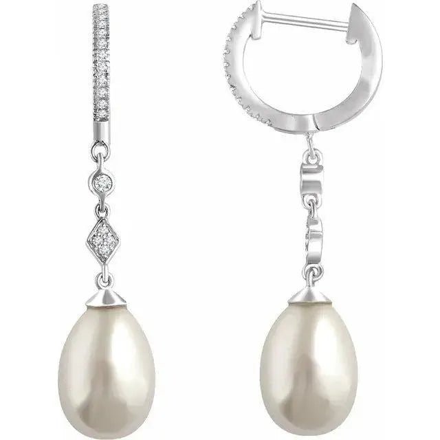 Close-up photo of 14K white gold dangle earrings featuring natural pearls and diamonds, handcrafted in NYC.