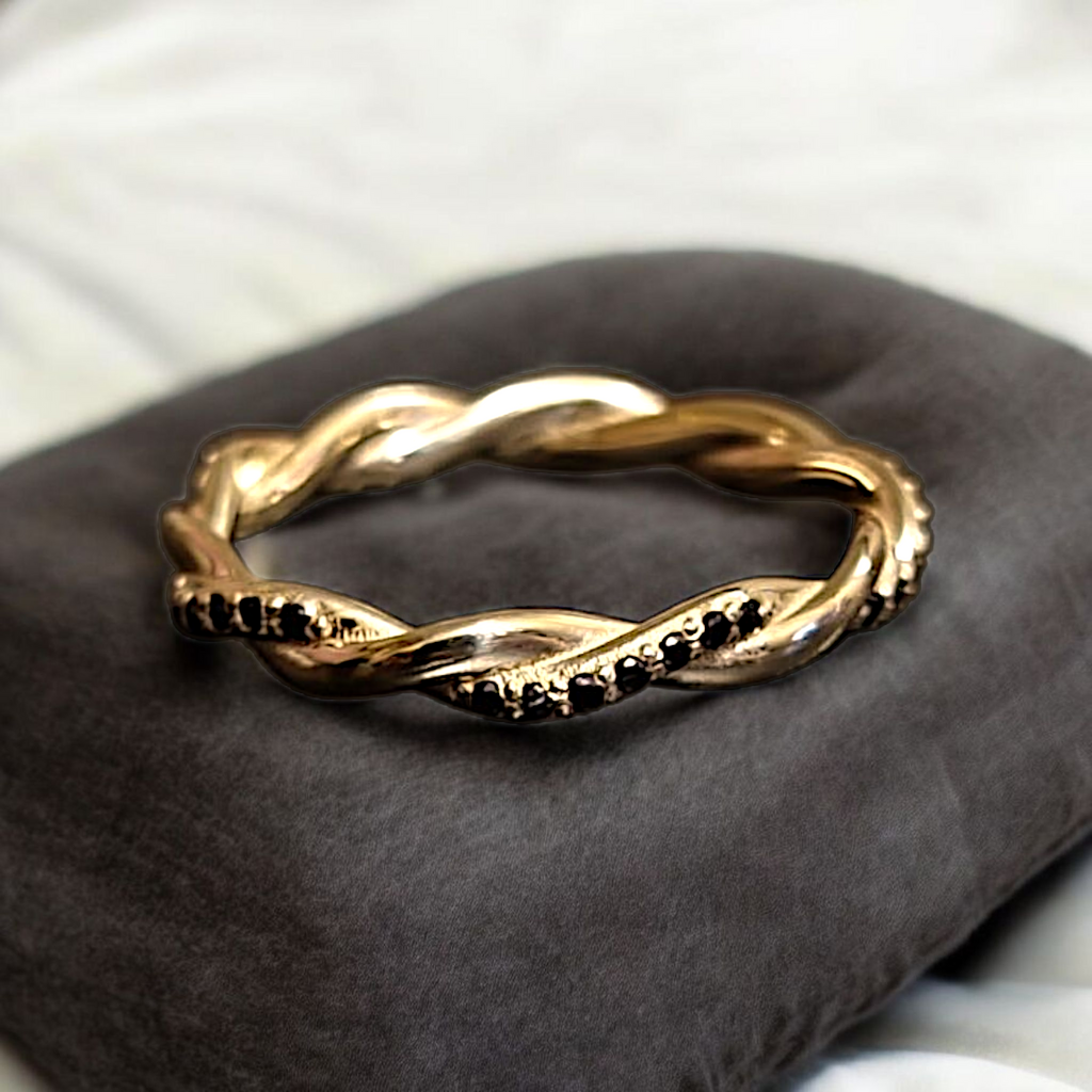 Black diamond twisted ring resting on velvet cushion, handcrafted in NYC
