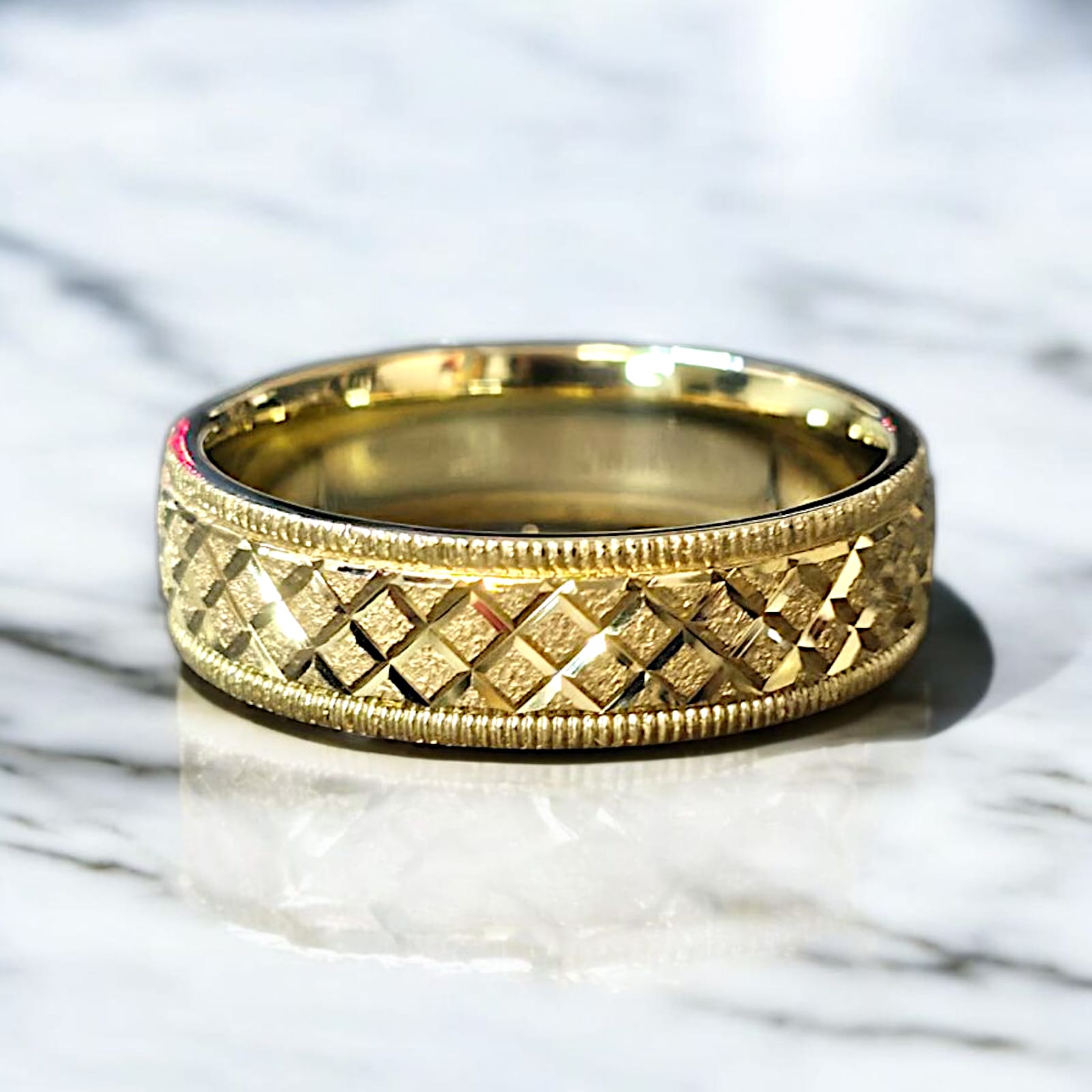 Crux cut gold wedding band laying flat on white marble surface