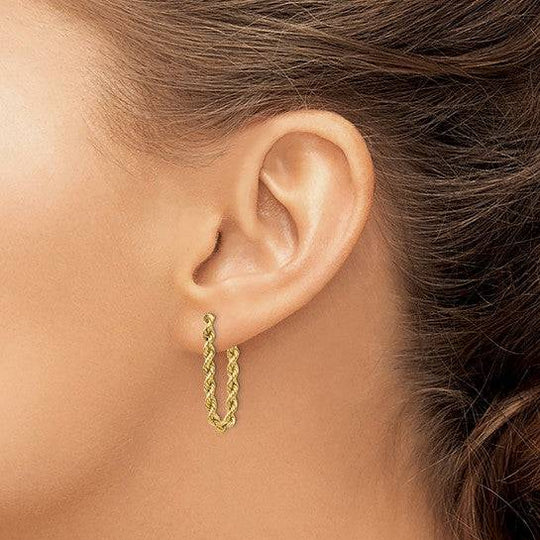 Woman wearing rope chain earrings in yellow gold, exuding effortless sophistication