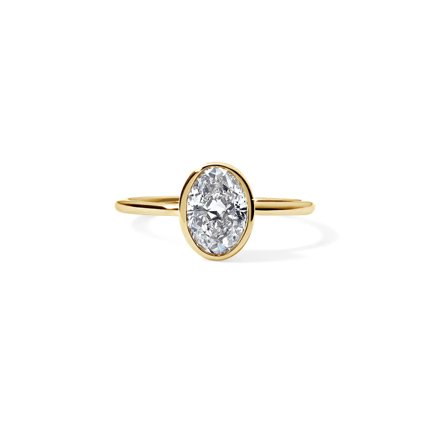 Studio-style macro image of 1 ct oval bezel engagement ring in 14K yellow gold on pure white.