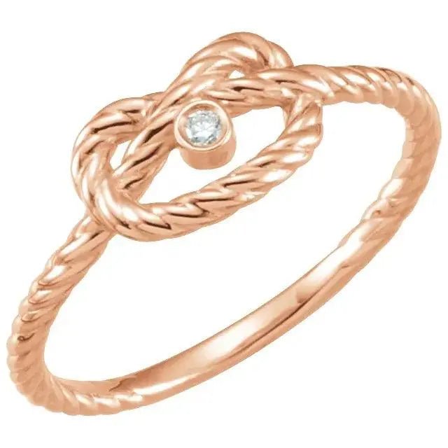 Amara Knot 14K rose gold love knot ring with a twisted band and a diamond accent, offering a romantic and timeless design.