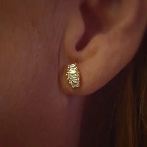 Close-up of a baguette earring in 14K yellow gold with lab-grown diamonds worn on an ear. A sustainable and elegant choice for everyday luxury.