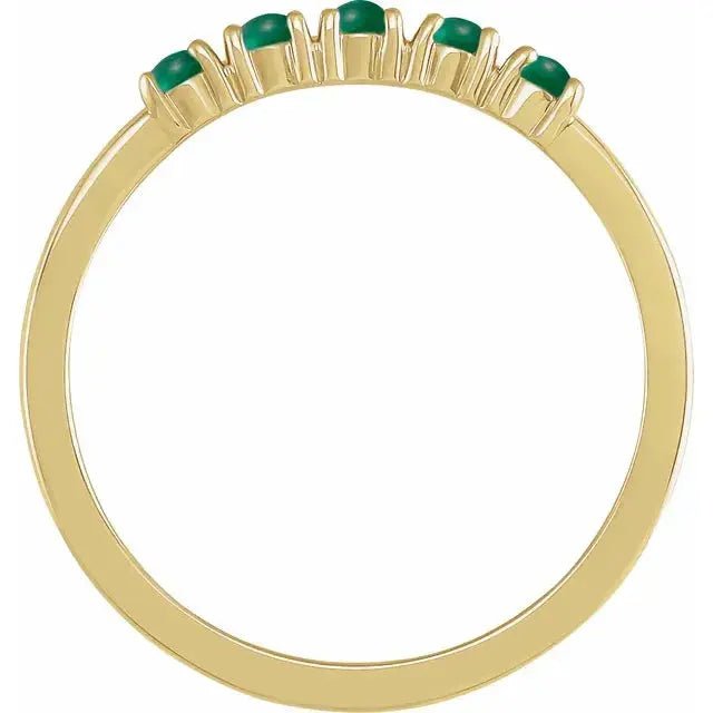 Side view of the 14K yellow gold emerald cabochon ring showcasing its slim band and secure prong setting for the seven green gemstones.