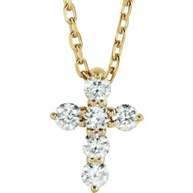 Close-up photo of 14K gold mini diamond cross necklace with natural diamonds, handcrafted in NYC.