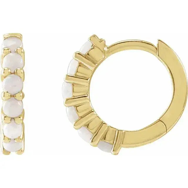 Close-up photo of 14K gold hoop earrings set with natural opals, handcrafted in NYC.