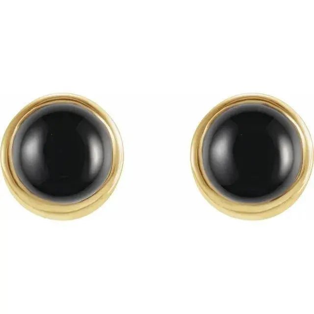 Close-up of handcrafted gold earrings featuring natural black onyx stones