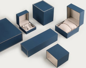 Set of blue jewelry boxes with watches and jewelry on a white background