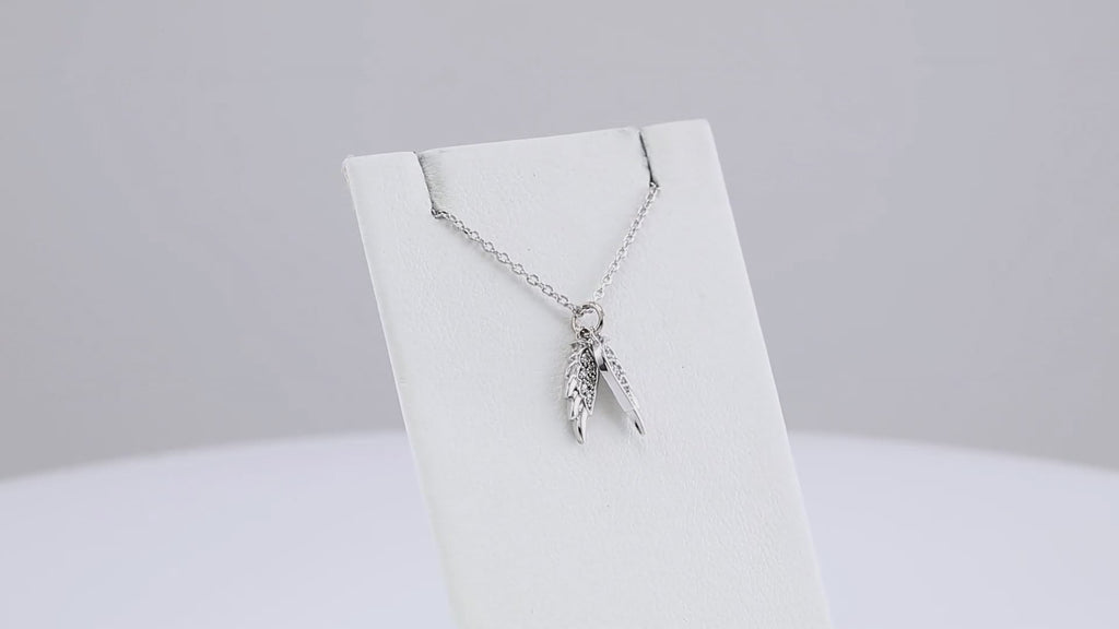 White gold Angel Wings Necklace displayed on a jewelry stand, highlighting its intricate design and sparkling diamond embellishments.
