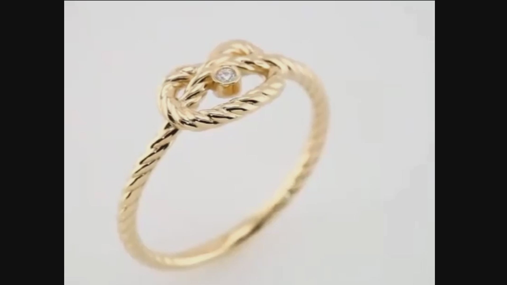 Close-up of the Amara Knot 14K gold love knot ring, highlighting its intricate twisted design and sparkling diamond accent.