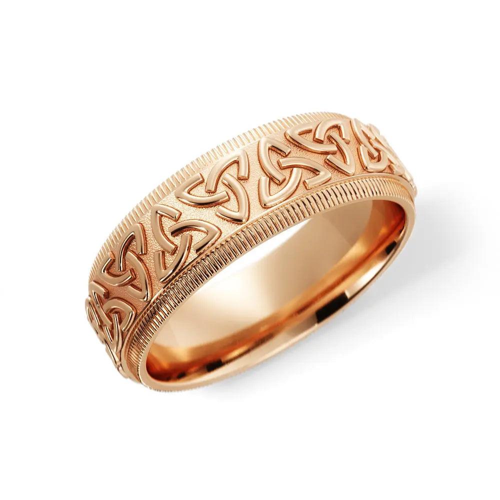 Celtic wedding ring in 14K rose gold featuring intricate Trinity knot designs on a 6mm band. A handcrafted men's wedding band with a comfort-fit design.