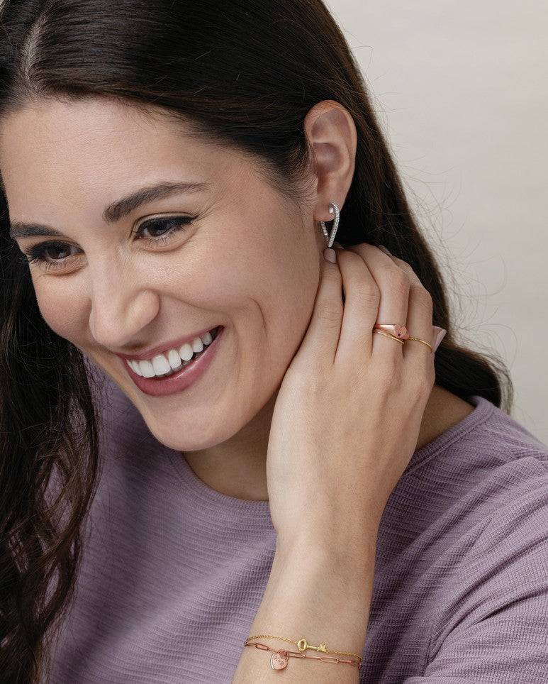 Woman wearing 14K gold Heart Hoop Earrings, highlighting their romantic and sophisticated design.